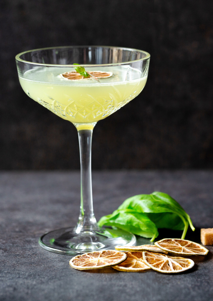 Le cocktail daïquiri à côté de citrons vert et de sucre de canne.